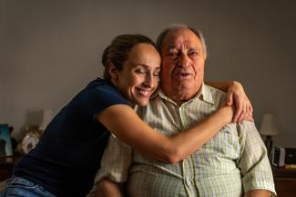 Older man and caregiver hugging